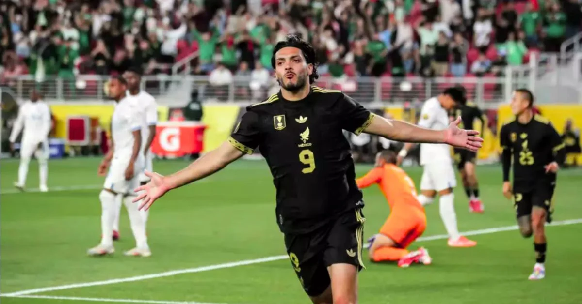 Mexican soccer player celebrates goal with arms outstretched during match.