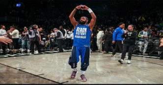 Kyrie Irving makes heart gesture on court wearing “Black History Black Voices” shirt.
