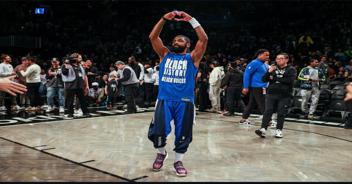 Kyrie Irving makes heart gesture on court wearing “Black History Black Voices” shirt.