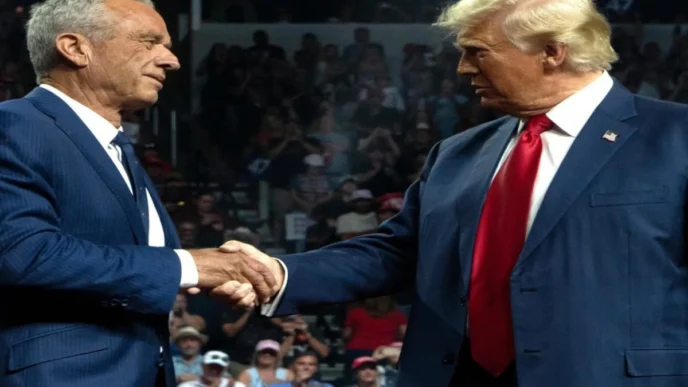 Robert F. Kennedy Jr. and Donald Trump shaking hands at a public event, both wearing blue suits, in front of a cheering crowd.
