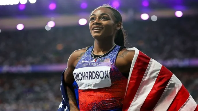Sha’Carri Richardson standing on a stadium track, wearing athletic gear