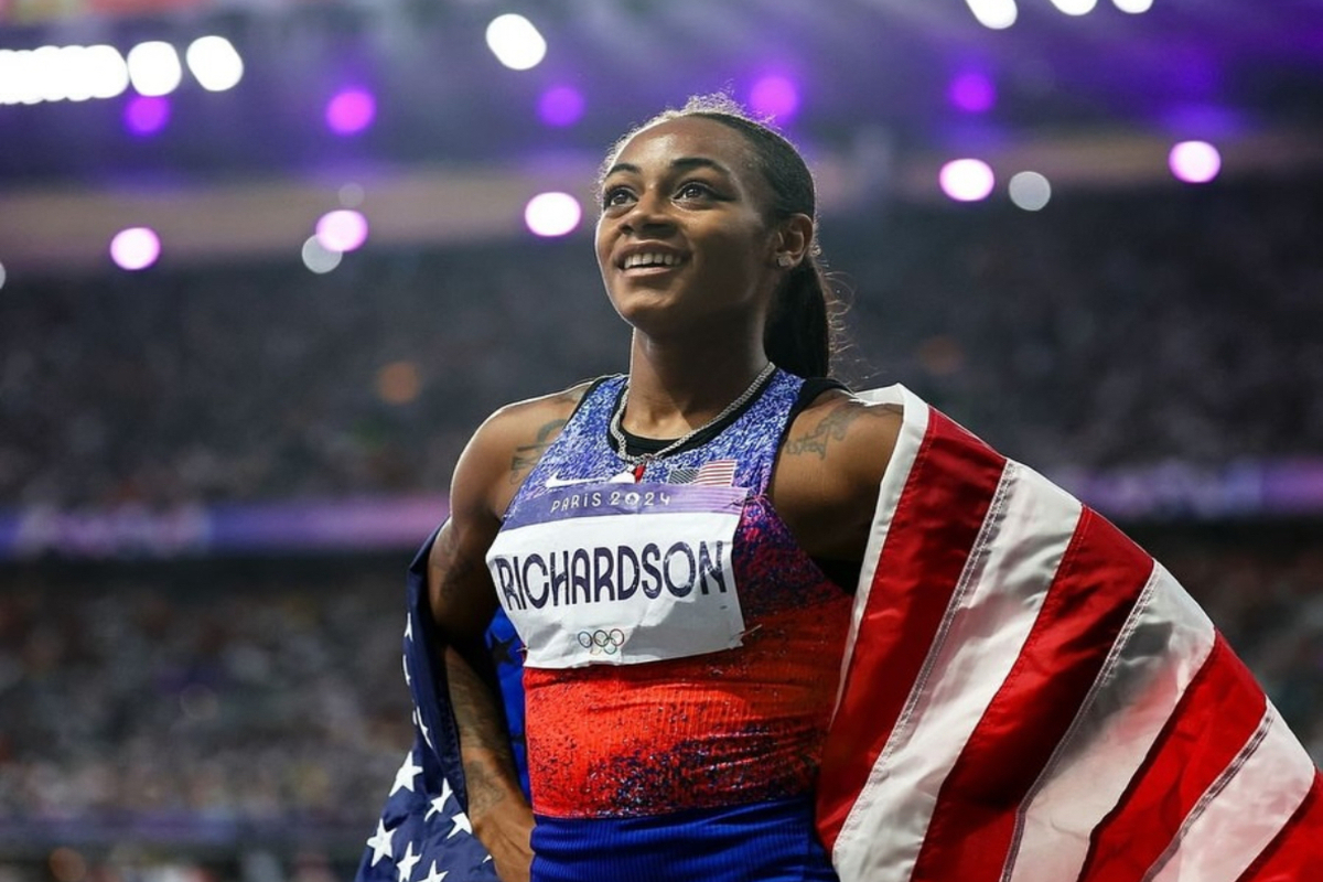 Sha’Carri Richardson standing on a stadium track, wearing athletic gear