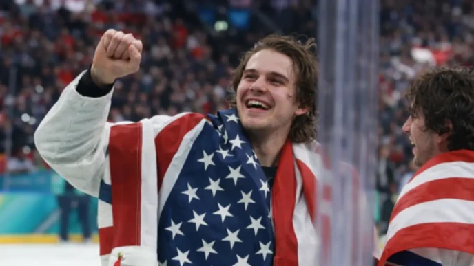 USA ice hockey player celebrating with American flag after gold medal win at the 2026 Winter Olympics