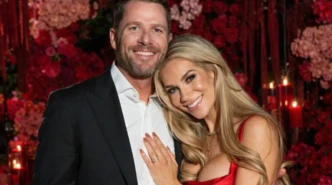 Allison Holker smiling in a red satin dress while posing with her partner at a romantic floral event backdrop