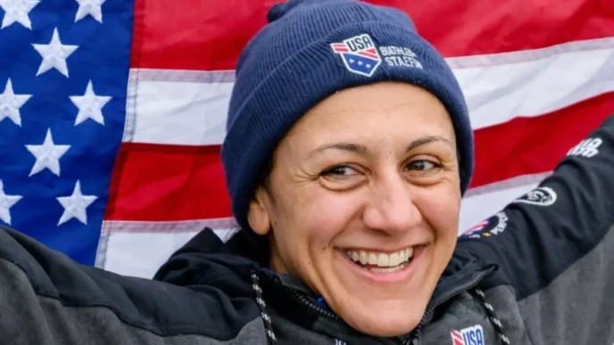 Elana Meyers Taylor smiling in front of the USA flag after winning monobob gold at the Winter Olympics