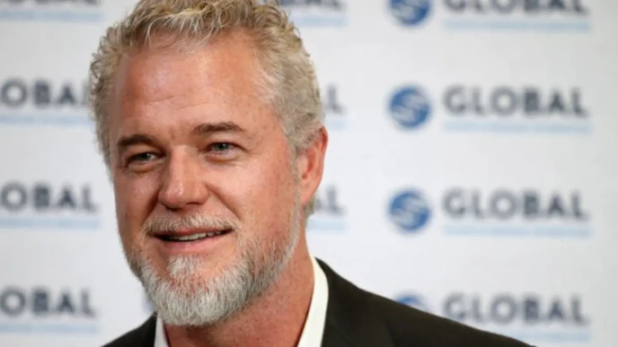 Eric Dane smiling at a media event with a GLOBAL backdrop behind him