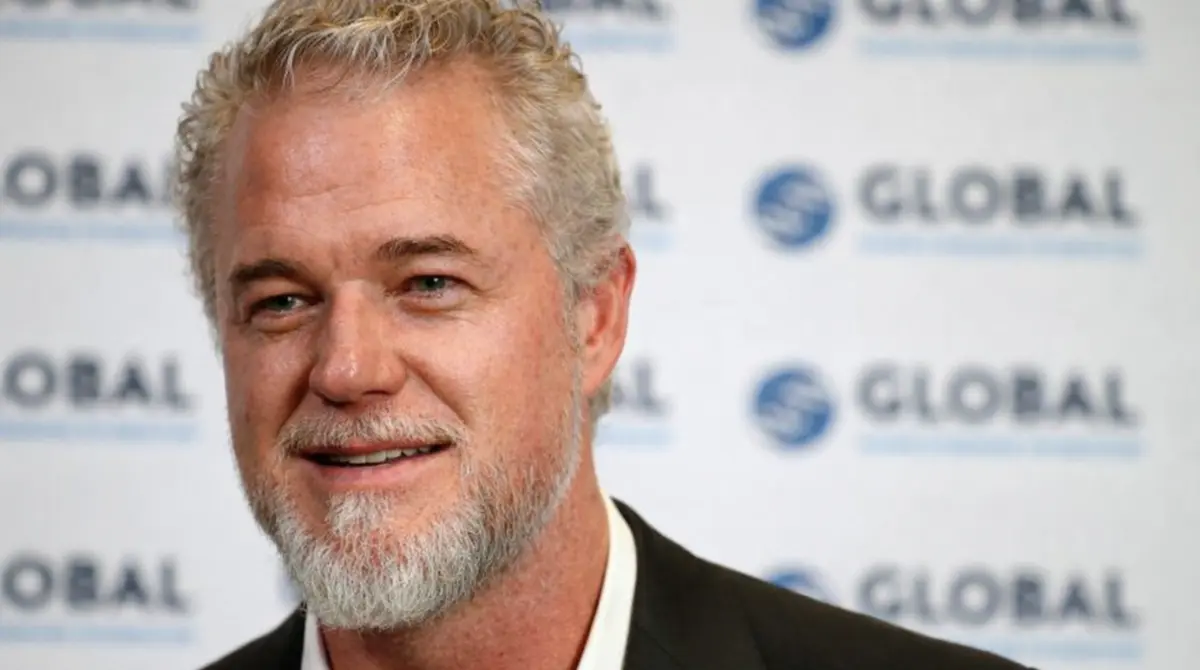 Eric Dane smiling at a media event with a GLOBAL backdrop behind him
