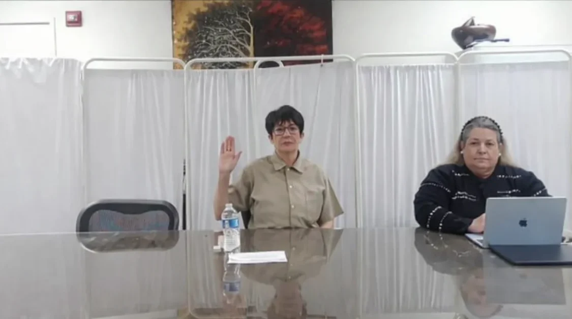 Ghislaine Maxwell raises her hand during a congressional deposition while refusing to answer questions related to Jeffrey Epstein as lawmakers observe.