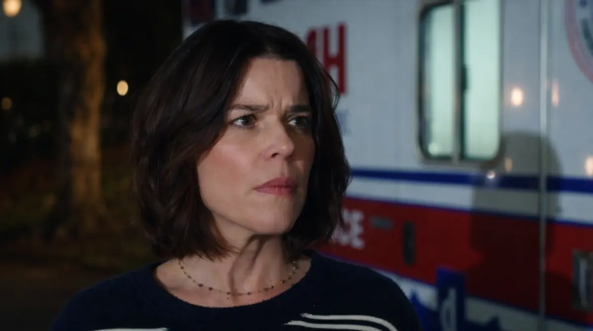 Scream movie scene showing a worried woman standing beside an ambulance at nigh