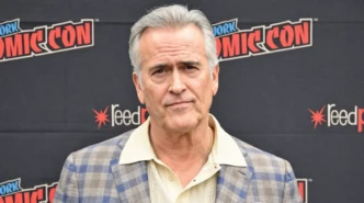 Bruce Campbell posing for a portrait at New York Comic Con in a plaid blazer
