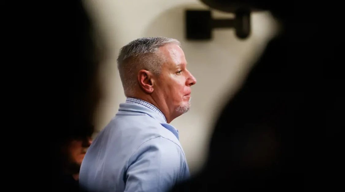 Colin Gray verdict courtroom photo showing a man in profile during trial proceedings, blurred gallery foreground.